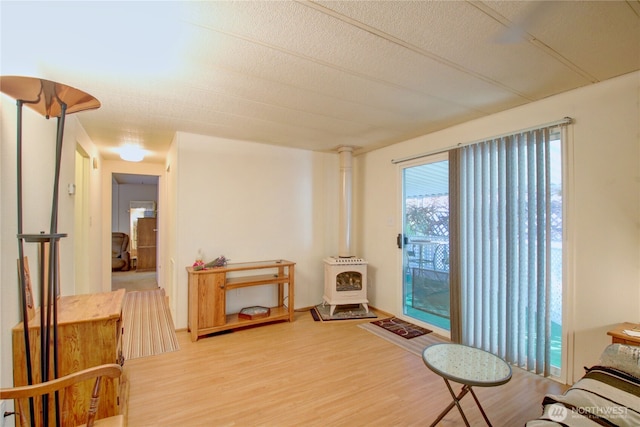 sitting room featuring a wood stove and light wood-style floors