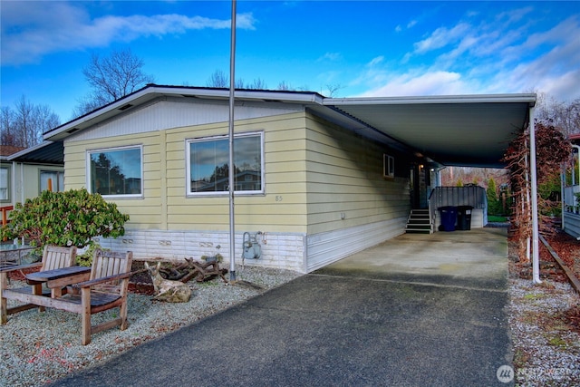 view of home's exterior featuring aphalt driveway and an attached carport