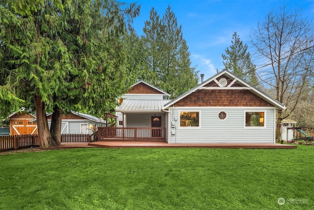 rear view of house featuring a yard, a storage unit, and a wooden deck