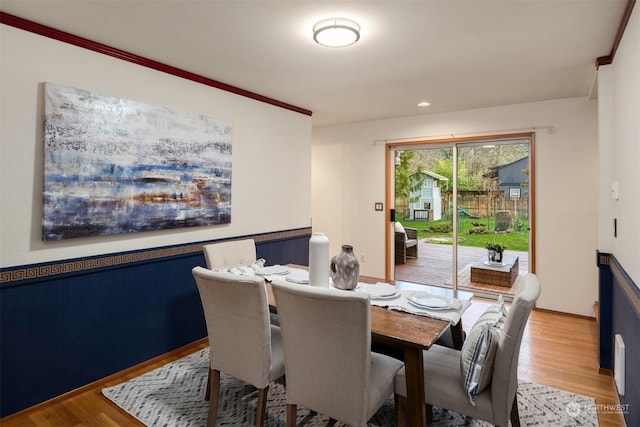 dining room with hardwood / wood-style floors and crown molding