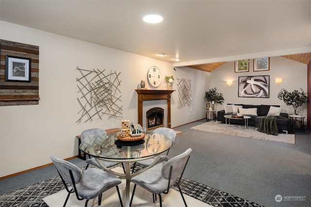 carpeted dining space featuring lofted ceiling