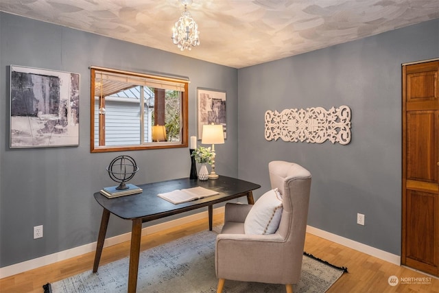 office with hardwood / wood-style flooring and a chandelier