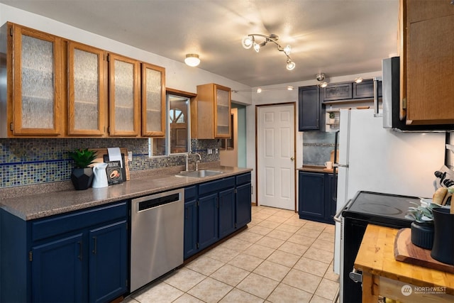 kitchen with stainless steel appliances, backsplash, blue cabinets, light tile patterned flooring, and sink