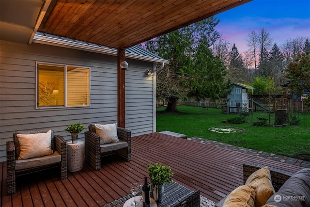 deck at dusk featuring a yard and an outdoor living space