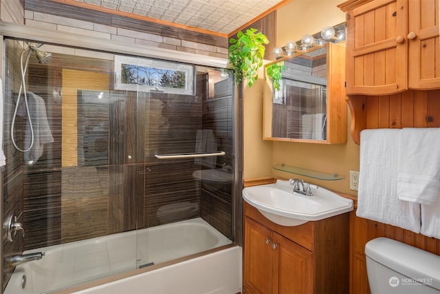 full bathroom featuring bath / shower combo with glass door, vanity, and toilet