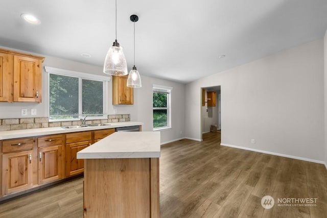 kitchen featuring a healthy amount of sunlight, sink, a kitchen island, and pendant lighting