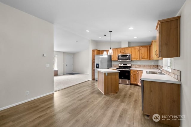 kitchen featuring hardwood / wood-style flooring, stainless steel appliances, a center island, hanging light fixtures, and sink