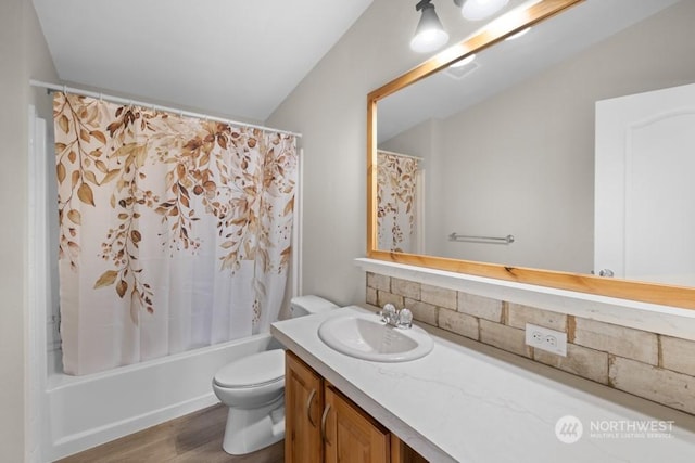 full bathroom featuring toilet, lofted ceiling, shower / bathtub combination with curtain, wood-type flooring, and vanity