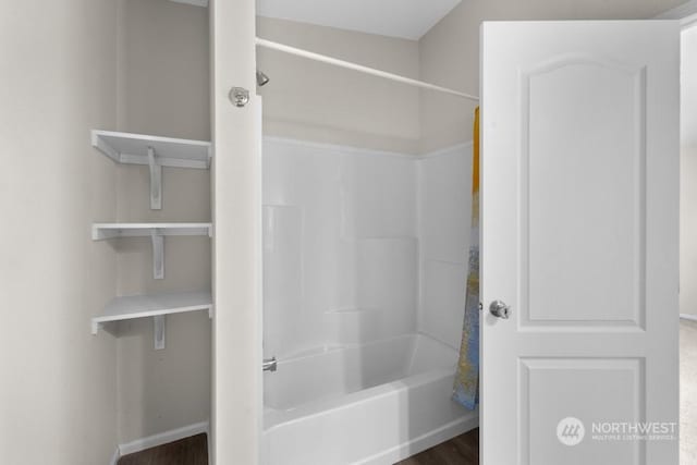 bathroom featuring shower / washtub combination and hardwood / wood-style floors