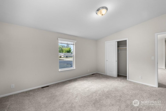 unfurnished bedroom featuring a closet, carpet flooring, and lofted ceiling