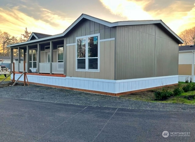 property exterior at dusk featuring covered porch