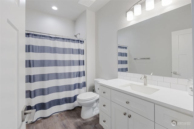 bathroom with toilet, a shower with shower curtain, vanity, and hardwood / wood-style flooring