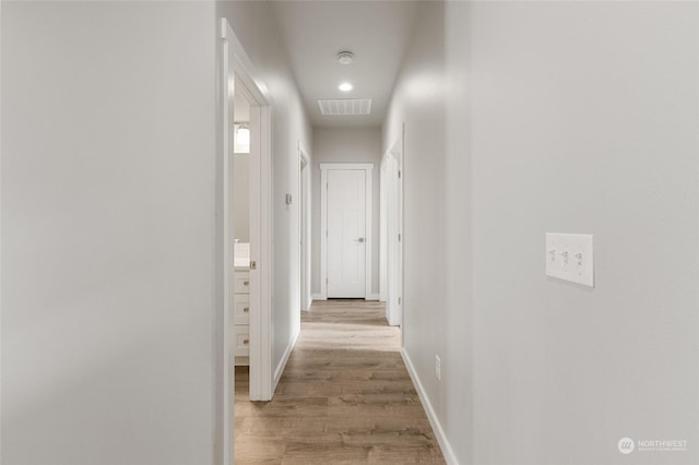 corridor with light hardwood / wood-style floors