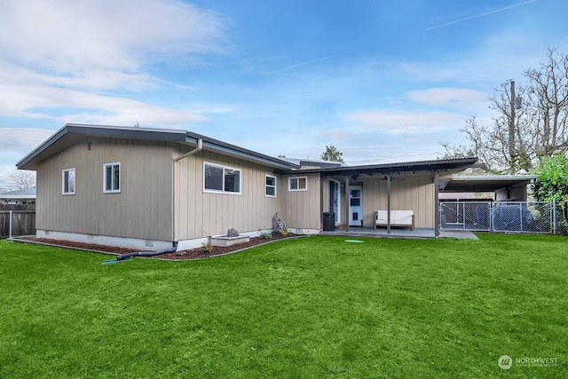 rear view of house featuring a yard and a carport