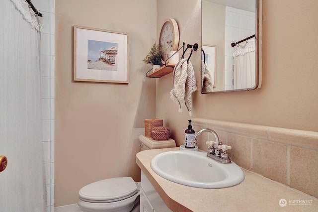 bathroom with toilet, vanity, and curtained shower