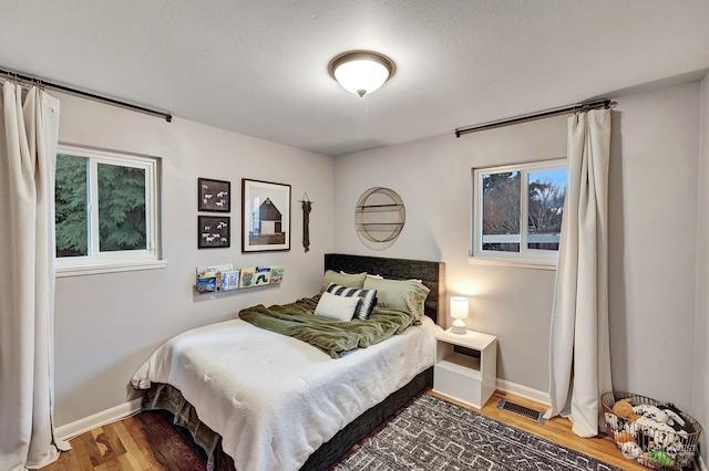 bedroom featuring a textured ceiling and hardwood / wood-style flooring