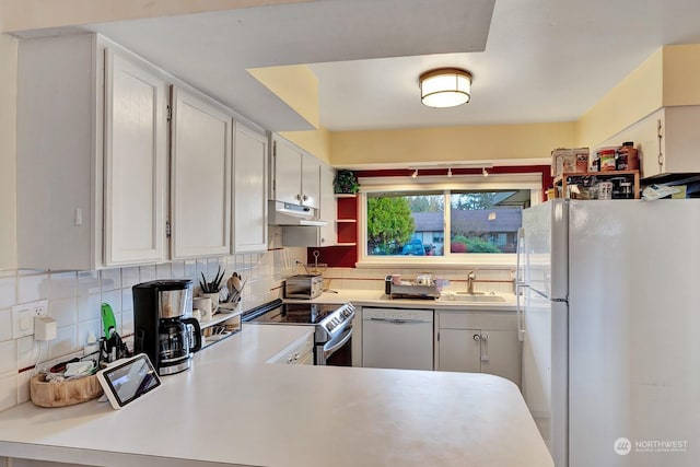 kitchen with white appliances, white cabinets, backsplash, and sink