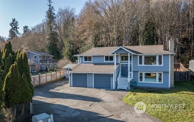 raised ranch featuring a front lawn and a garage