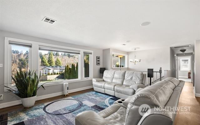 living room featuring a wealth of natural light, a chandelier, and hardwood / wood-style floors