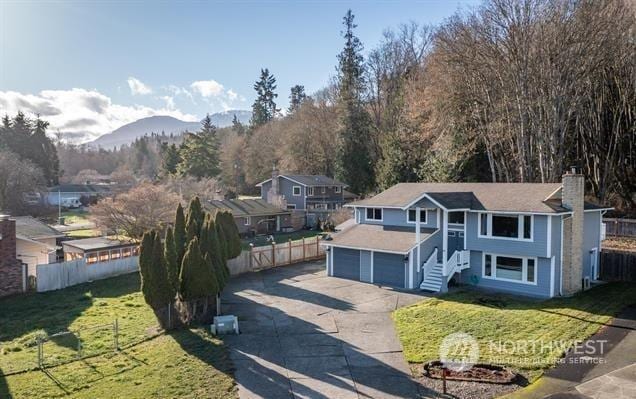 view of front facade with a front lawn, a mountain view, and a garage