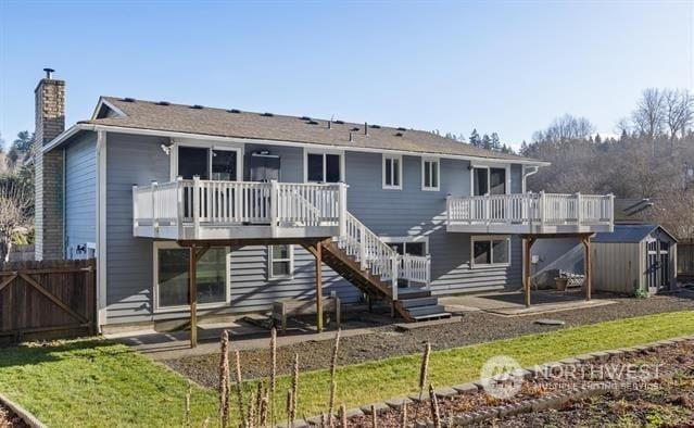 back of property with a storage shed and a deck