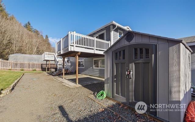 view of property exterior featuring a deck and a storage shed