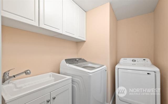 laundry room with sink, independent washer and dryer, and cabinets