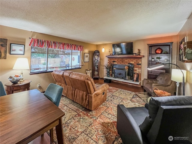 living room featuring a brick fireplace, a textured ceiling, and light hardwood / wood-style flooring