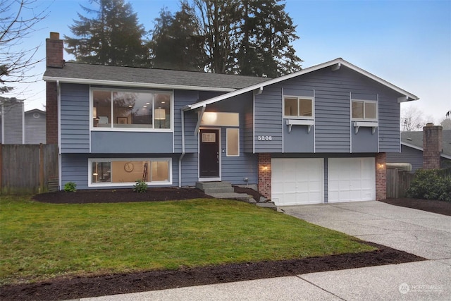 raised ranch with a front yard and a garage