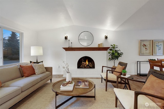 living room with a fireplace, vaulted ceiling, and hardwood / wood-style flooring