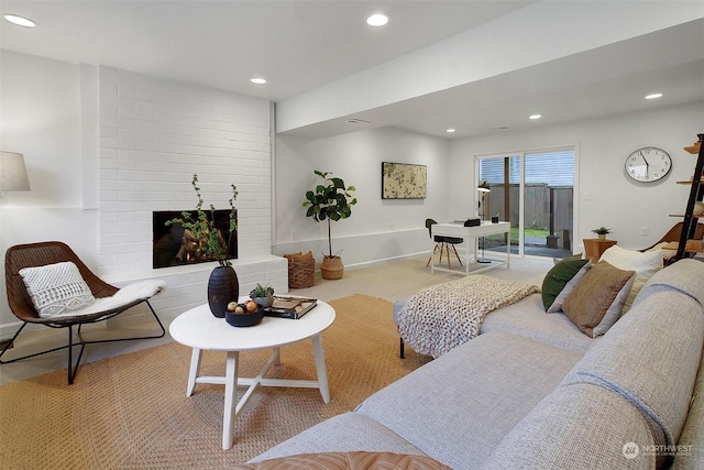 living room featuring a large fireplace and light carpet