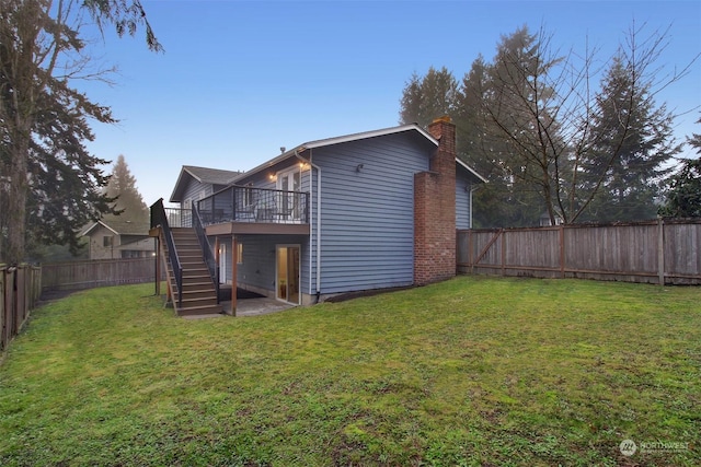 back of property with a wooden deck and a lawn