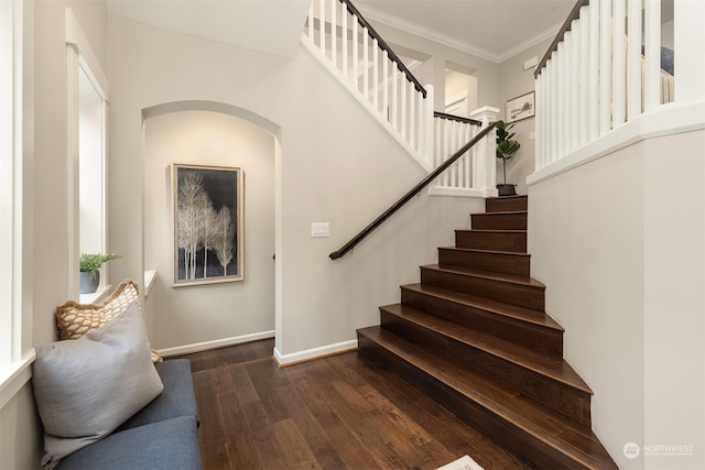 stairs featuring ornamental molding and wood-type flooring