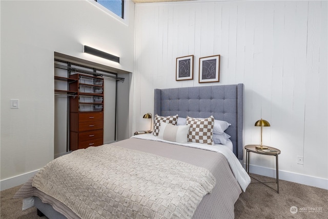 bedroom with wood walls, a towering ceiling, and carpet floors