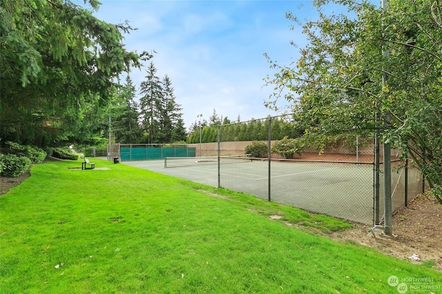 view of tennis court featuring a yard