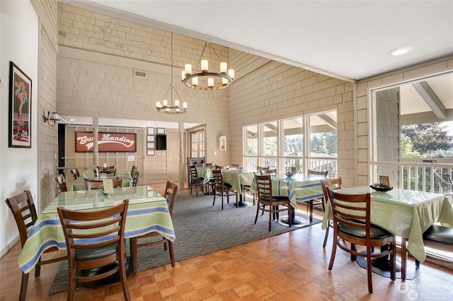 dining space featuring parquet flooring and a chandelier