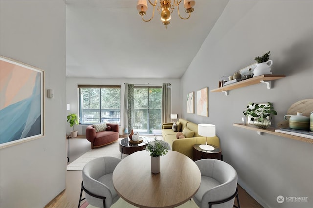 dining room featuring lofted ceiling, an inviting chandelier, and light hardwood / wood-style flooring