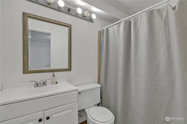 bathroom with toilet, vanity, and a shower with curtain