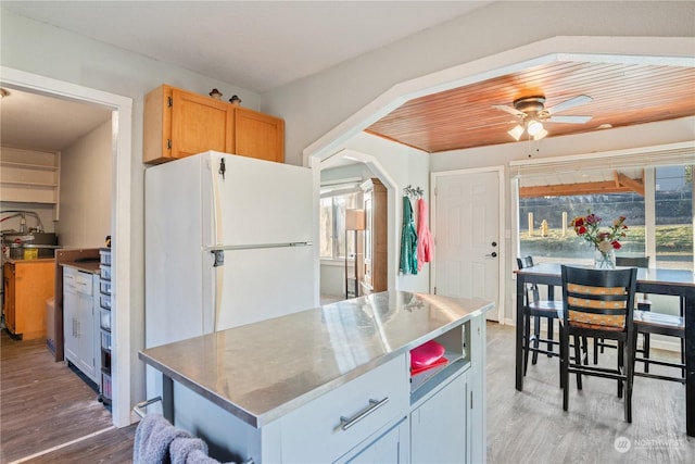 kitchen with white refrigerator, a center island, hardwood / wood-style flooring, and ceiling fan