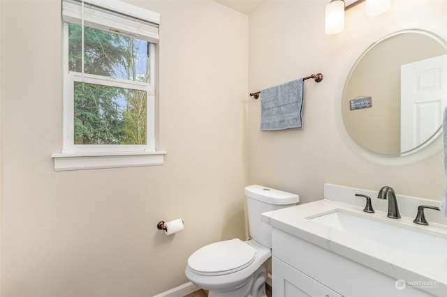 bathroom featuring toilet, a wealth of natural light, and vanity