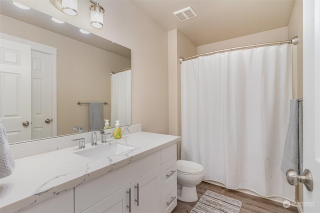 bathroom featuring toilet, vanity, and hardwood / wood-style flooring