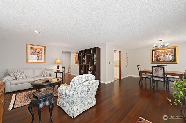 living room with a notable chandelier, a textured ceiling, and dark hardwood / wood-style floors