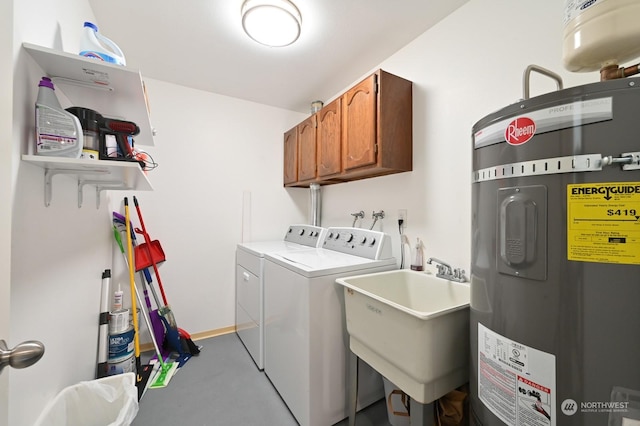 clothes washing area featuring cabinets, sink, washer and clothes dryer, and strapped water heater