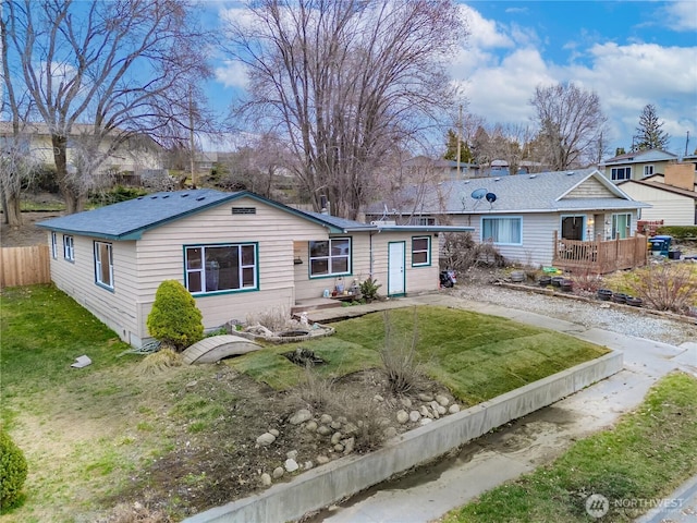 ranch-style house with a front lawn and fence