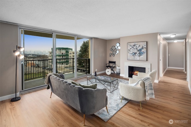 living room featuring hardwood / wood-style flooring, expansive windows, and a textured ceiling