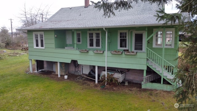 rear view of house featuring a lawn