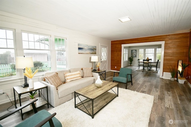 living room with dark wood-type flooring, wooden walls, and wood ceiling
