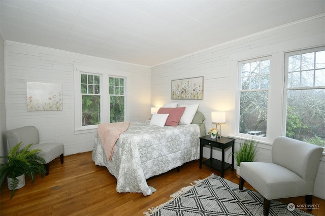 bedroom with dark hardwood / wood-style flooring and multiple windows