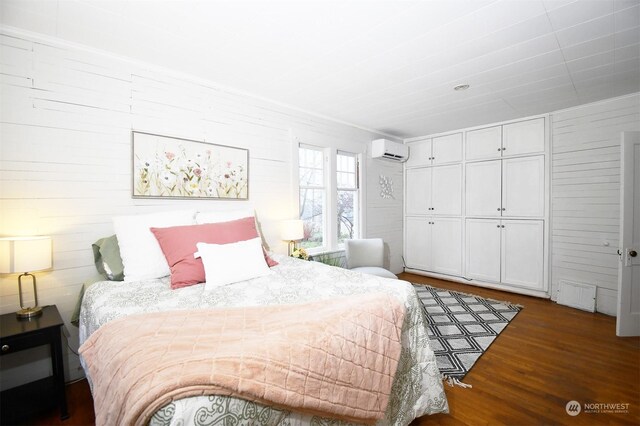 bedroom with a wall mounted AC, a closet, and dark hardwood / wood-style flooring