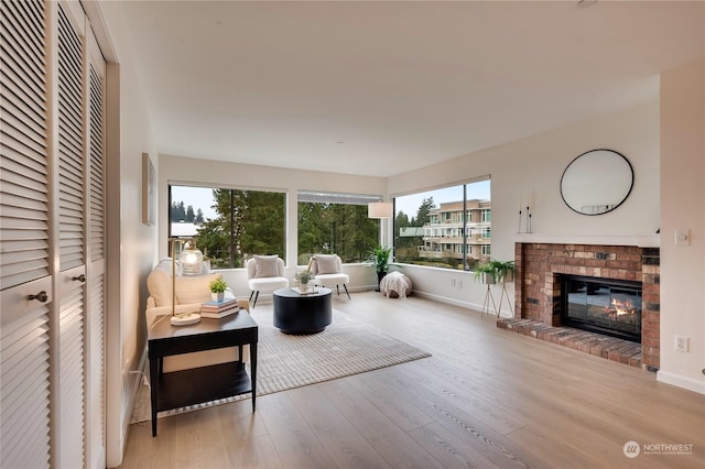 living room with a brick fireplace and light hardwood / wood-style floors